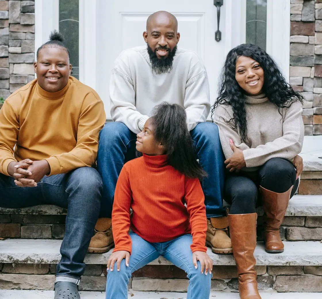 Family sitting together on the front steps of their home