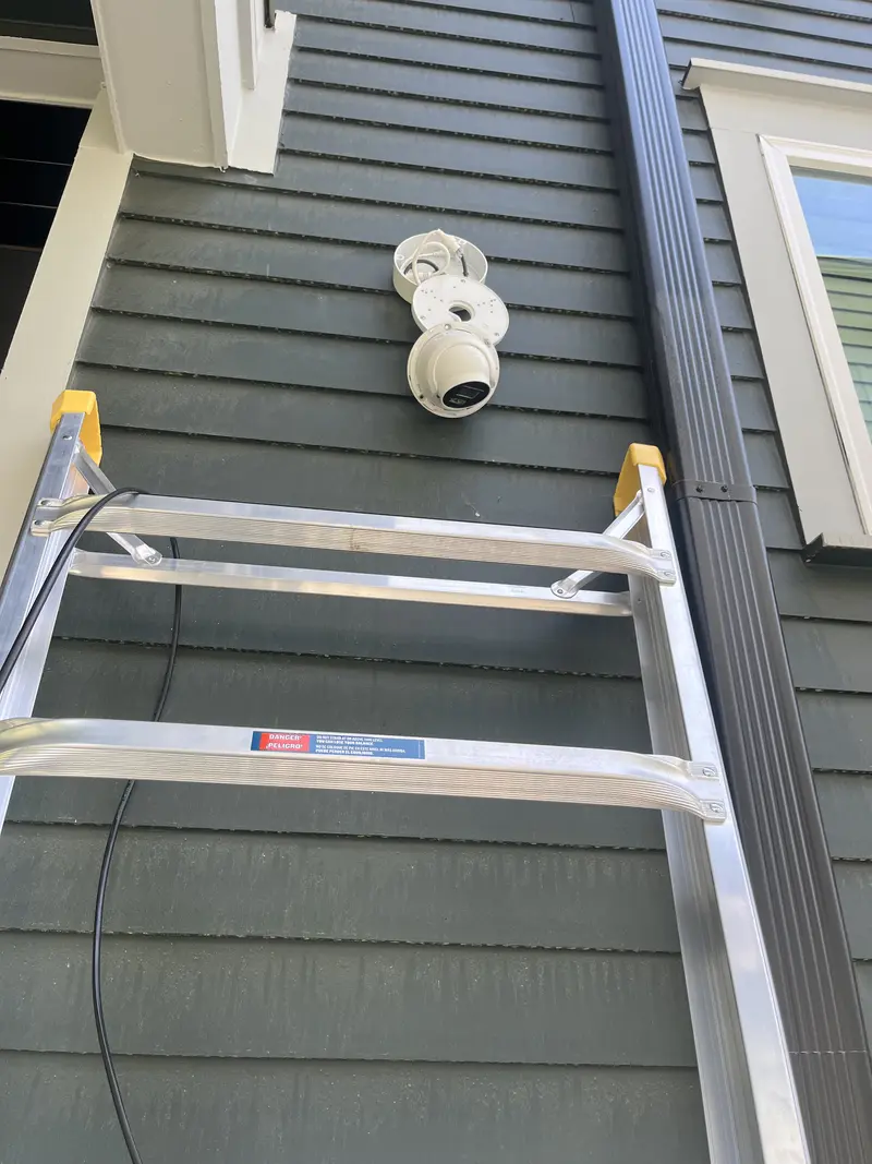Camera installed on siding beside a ladder